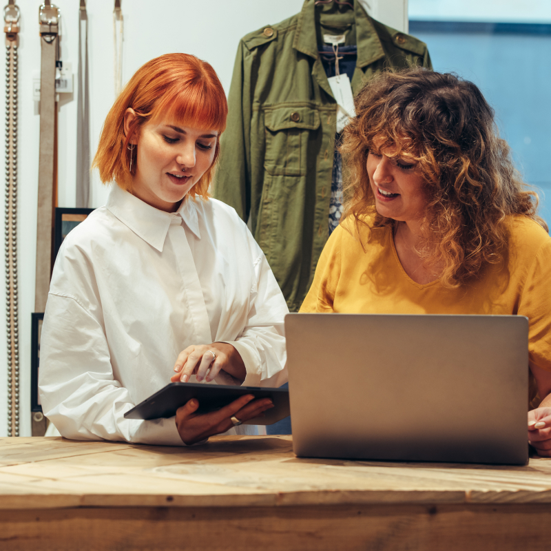 Zwei Personen arbeiten mit Laptop und Tablet in industrieller Umgebung. CANCOM und HPE Aruba bieten IoT-Supportlösungen.